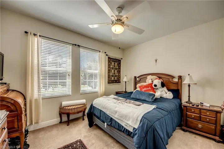 Carpeted bedroom featuring a ceiling fan and baseboards