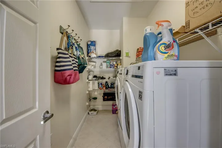 Laundry area featuring light tile patterned floors and separate washer and dryer