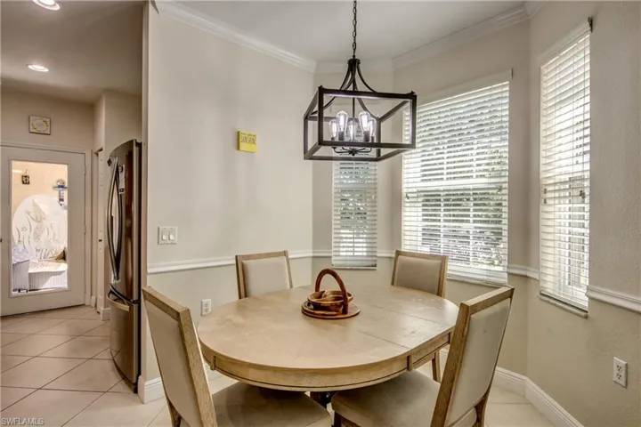 Dining area featuring light tile patterned flooring and crown molding