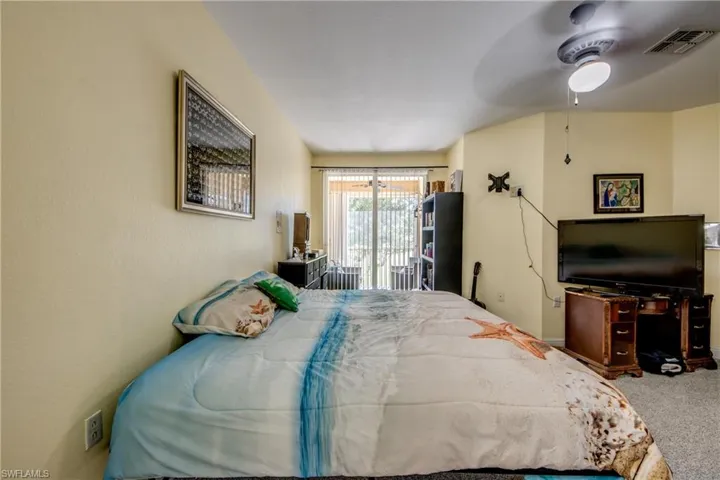 Bedroom with access to exterior, ceiling fan, and carpet floors