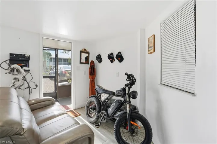 Workout room with light wood-style flooring and baseboards - Virtually Edited Image