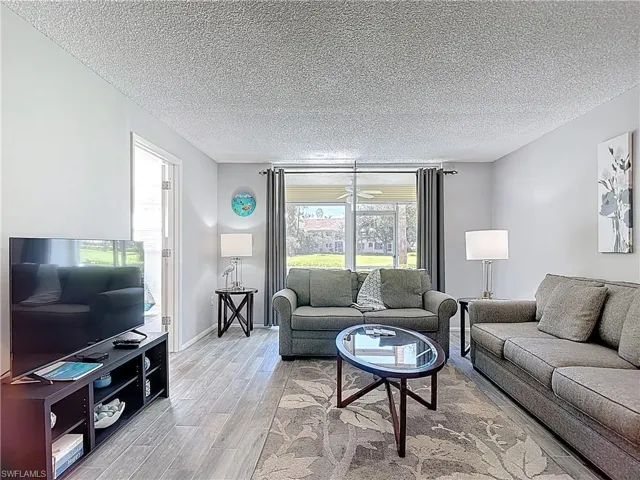 Living room featuring wood finished floors and a textured ceiling