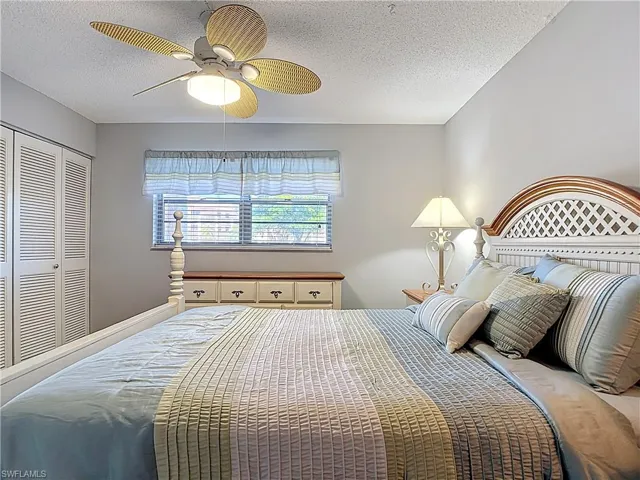 Bedroom with a textured ceiling, a closet, and ceiling fan