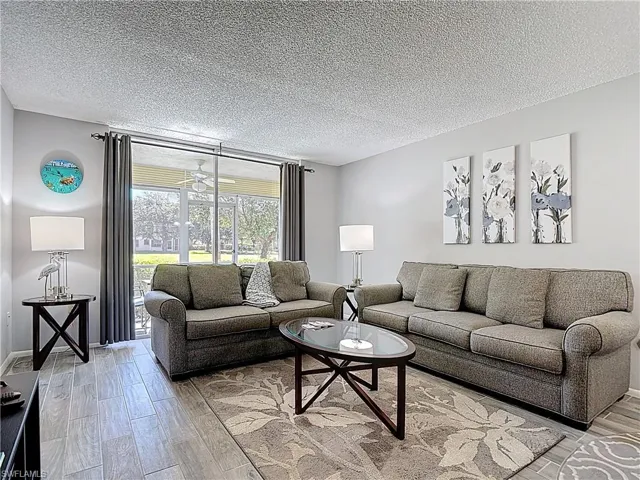 Living room featuring light wood finished floors and a textured ceiling