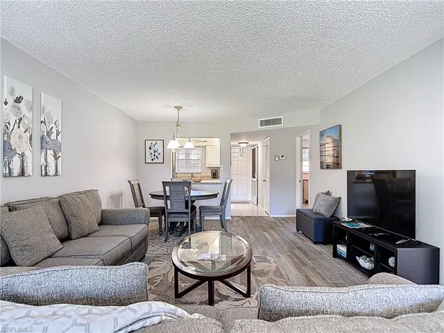 Living room with wood finished floors and a textured ceiling