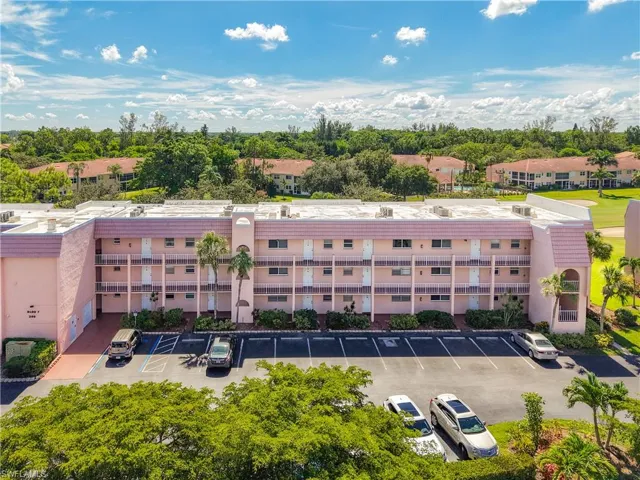 View of apartment building / complex with uncovered parking