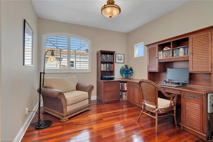Home office featuring dark hardwood / wood-style flooring and plenty of natural light