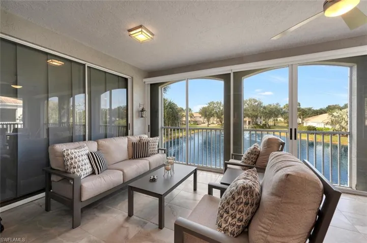Sunroom with ceiling fan and a water view