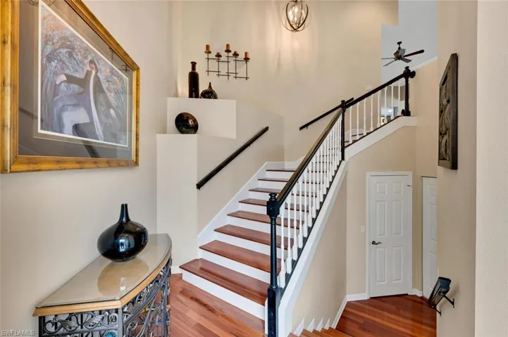 Stairway with wood-type flooring and ceiling fan