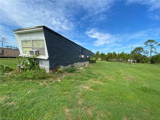 View of property exterior featuring a lawn