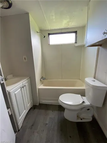 Full bathroom with shower / bathing tub combination, toilet, vanity, and hardwood / wood-style flooring
