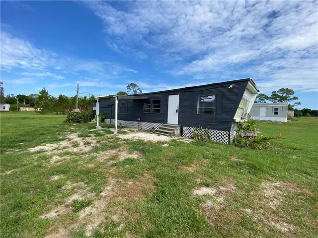 Rear view of house featuring a yard