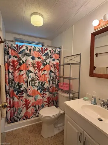 Guest Bathroom featuring shower, toilet, vanity, tile patterned floors,