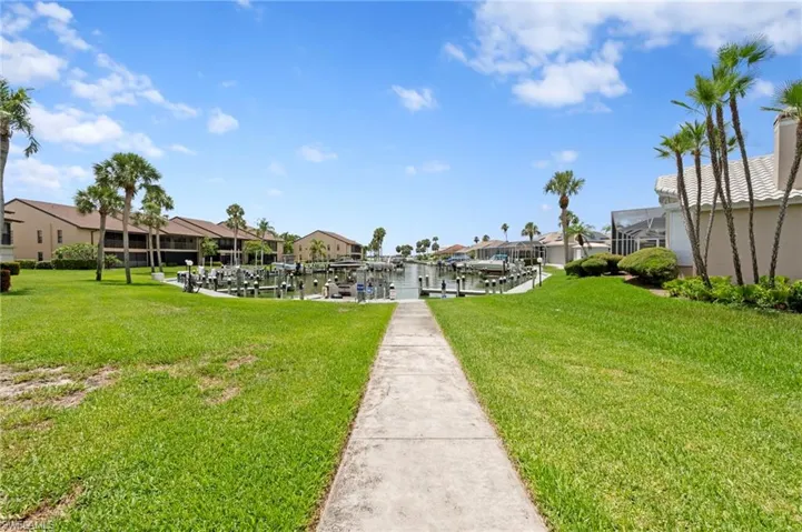 Surrounding community featuring a dock, boat lift, a residential view, and a lawn