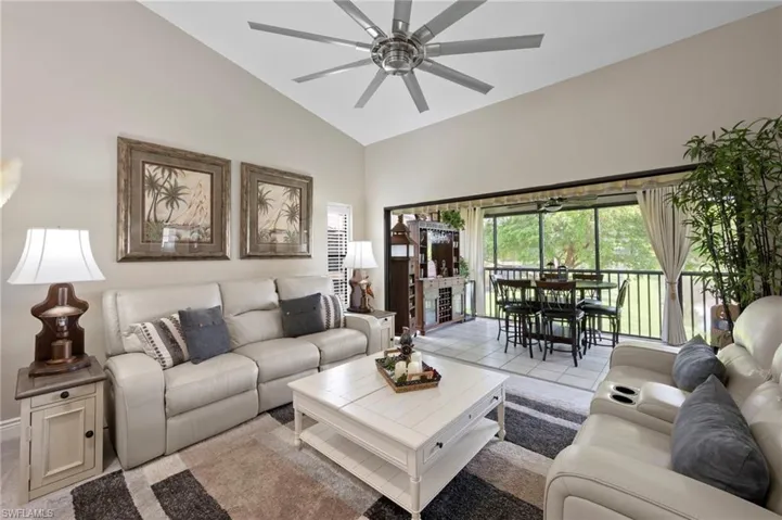 Living room featuring a ceiling fan and high vaulted ceiling