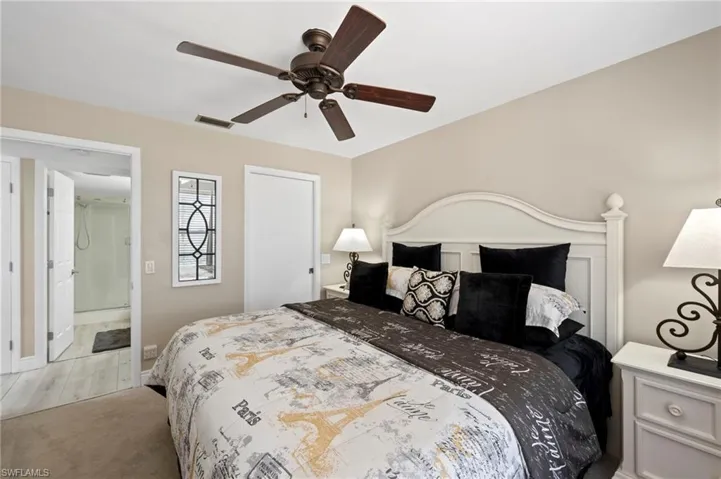 Bedroom featuring light colored carpet, a ceiling fan, and baseboards