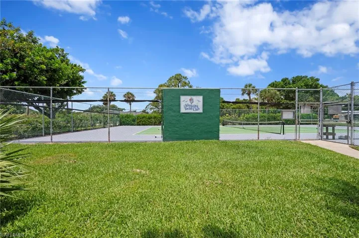 View of community with a gate and a tennis court