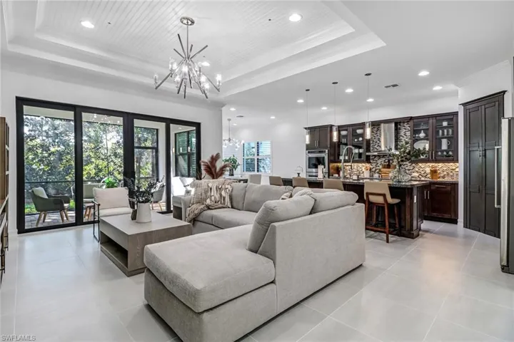 Living area with hanging lights, ornamental molding, and light tile patterned floors