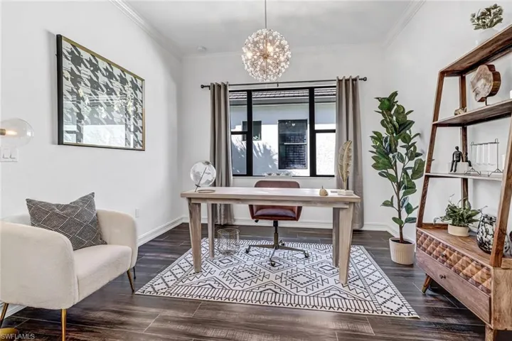 Office space featuring a chandelier, crown molding, and dark wood finished floors