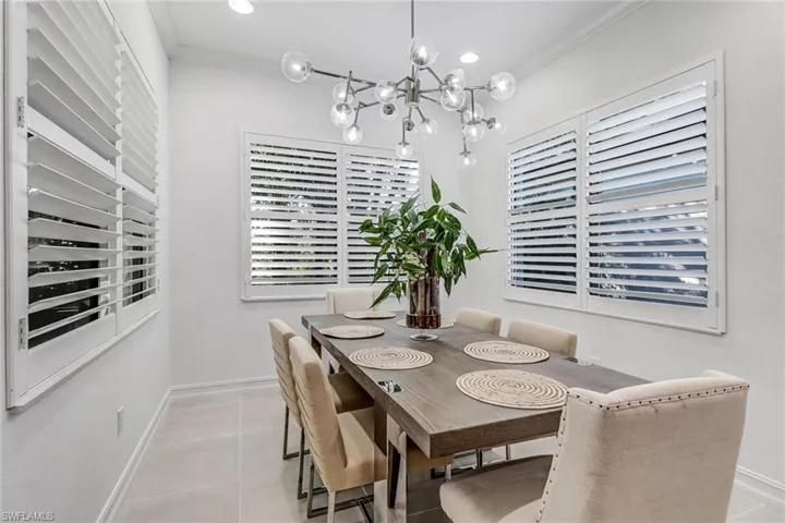 Dining room featuring crown molding, a chandelier, light tile patterned flooring, and plenty of natural light