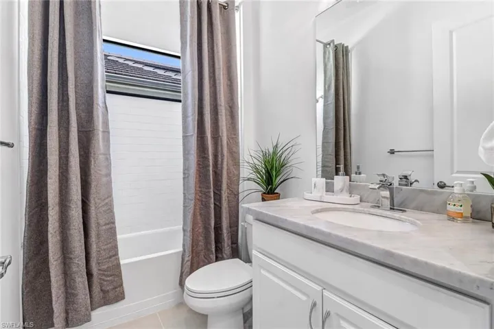 Bathroom featuring vanity, light tile patterned flooring, and shower / tub combo