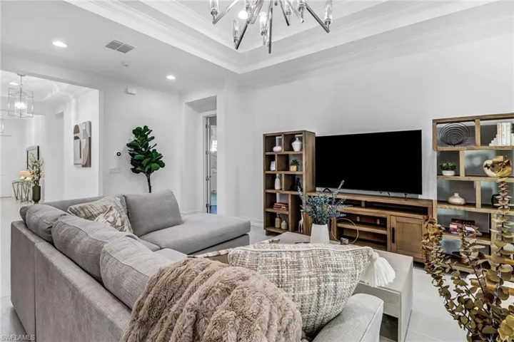 Living area with hanging lights and ornamental molding