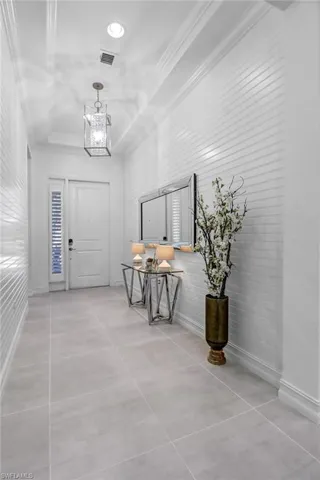 Foyer featuring hanging lights and ornamental molding
