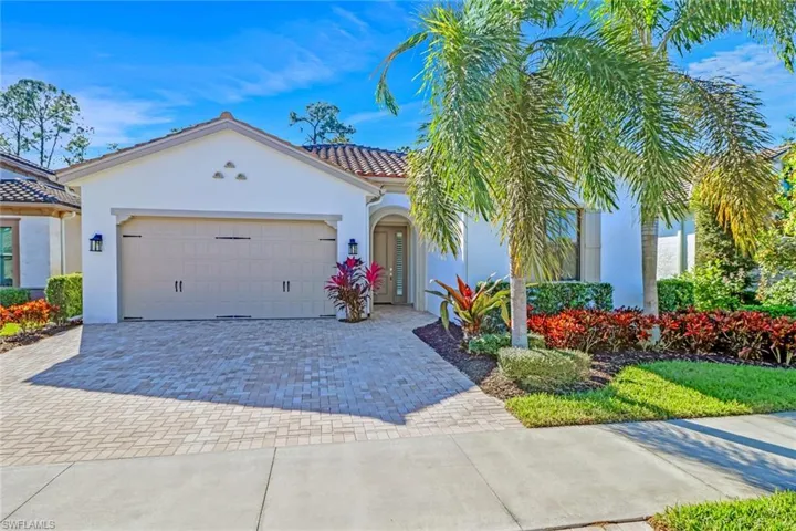 Mediterranean / spanish-style home with an attached garage, decorative driveway, stucco siding, and a tiled roof