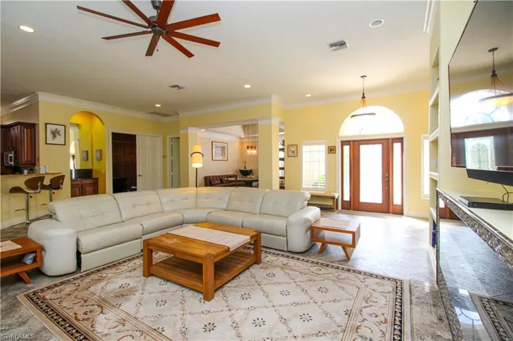 Living room with ceiling fan and crown molding