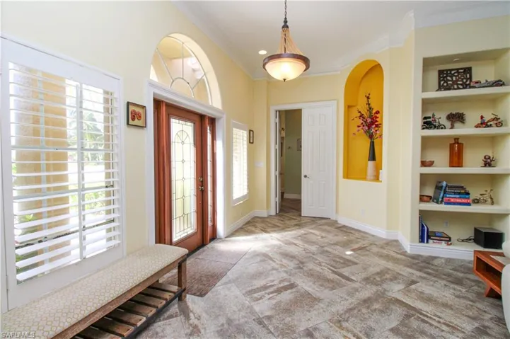 Entrance foyer featuring ornamental molding and plenty of natural light