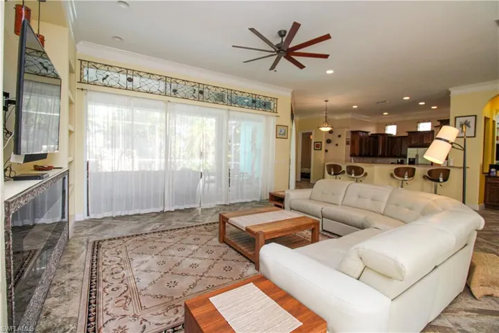 Living room featuring ceiling fan and ornamental molding