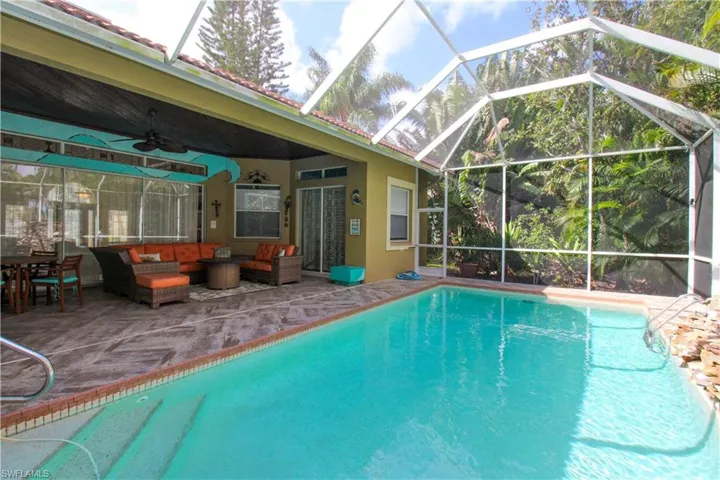 View of pool featuring a lanai, ceiling fan, a patio, and an outdoor living space