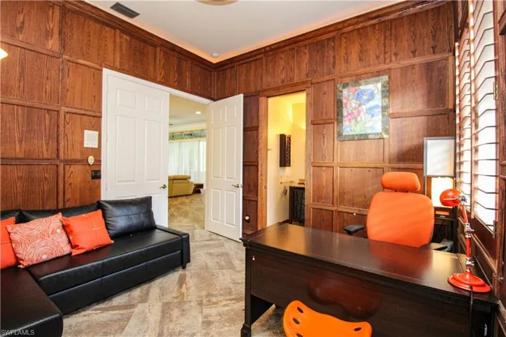 Office space featuring wooden walls and light carpet