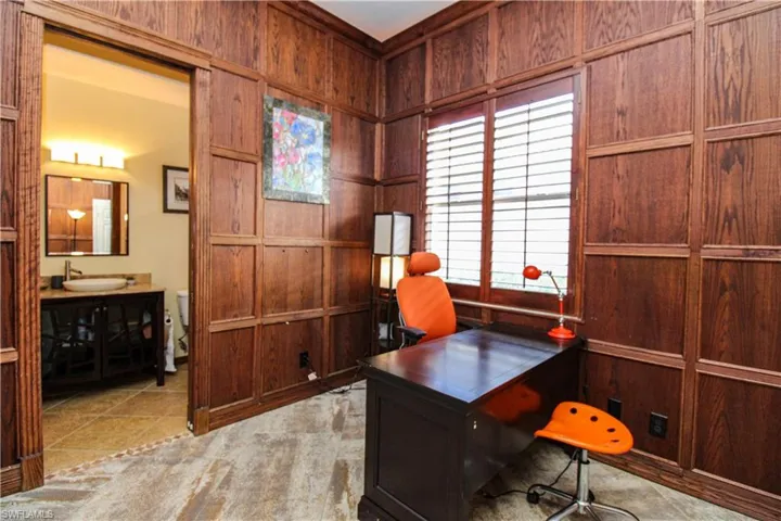 Home office with wood walls, sink, and light tile patterned flooring