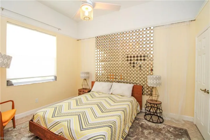 Bedroom with ceiling fan and tile patterned flooring