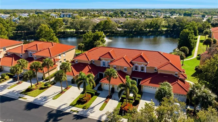 Drone / aerial view of a nearby body of water and a tree filled landscape
