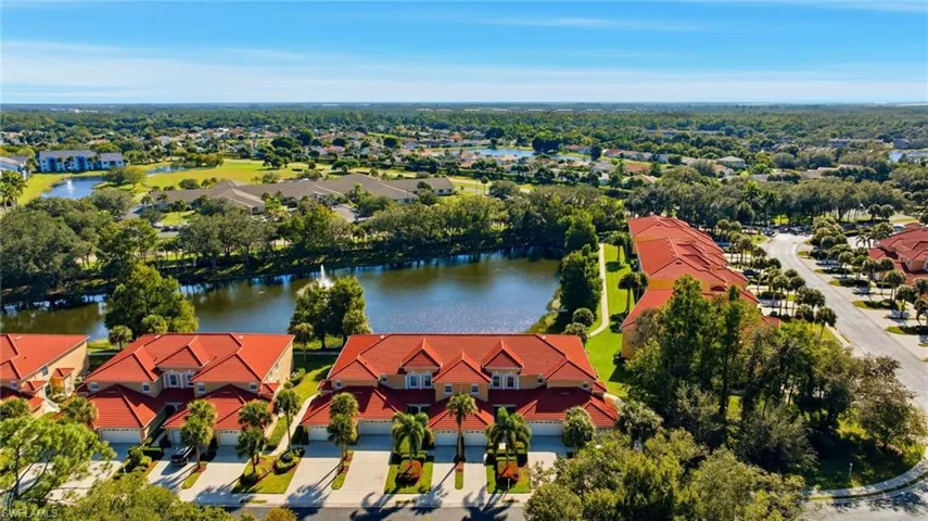 Drone / aerial view of a nearby body of water and a tree filled landscape
