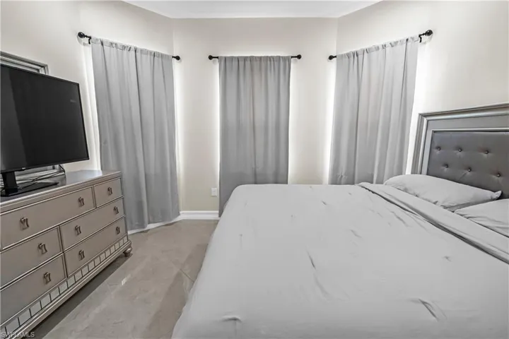 Corner windows with light gray drapery and dark-finish rods
