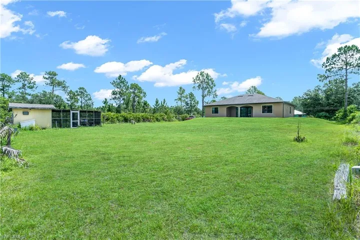 Expansive green lawn with a detached auxiliary structure
