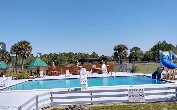 View of pool with a patio area and a water slide