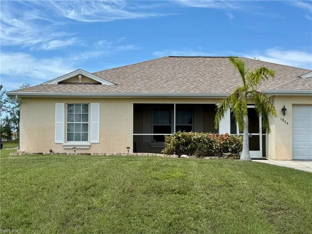 Single story home with a garage and a front lawn