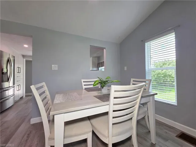 Dining space featuring vaulted ceiling and wood finished floors