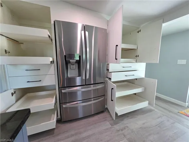 Kitchen featuring stainless steel fridge with ice dispenser and light wood finished floors