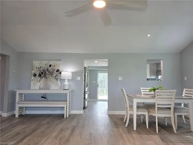 Dining space with lofted ceiling, wood finished floors, ceiling fan, and recessed lighting