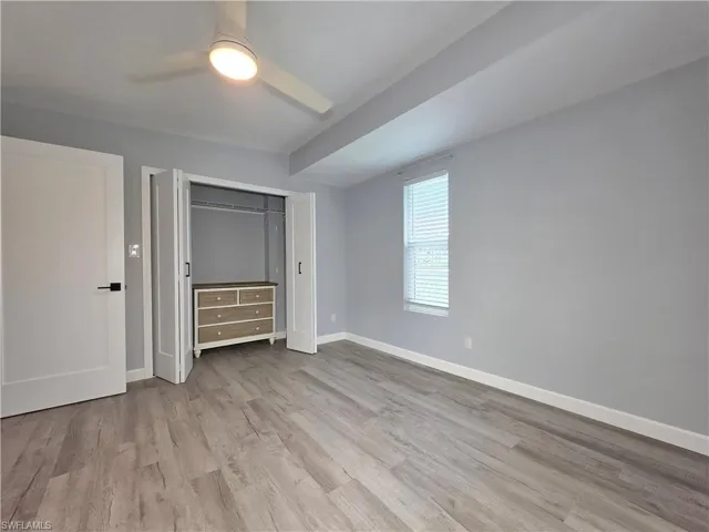 Unfurnished bedroom with wood finished floors, a closet, and ceiling fan