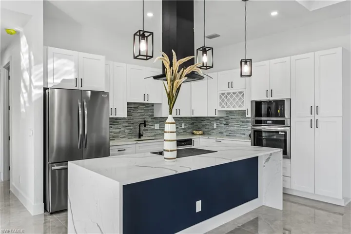 The full suite kitchen is fully equipped with stainless steel appliances, quartz countertops, a beautiful island with electric cooktop, wall oven, dishwasher, microwave, and refrigerator/freezer.