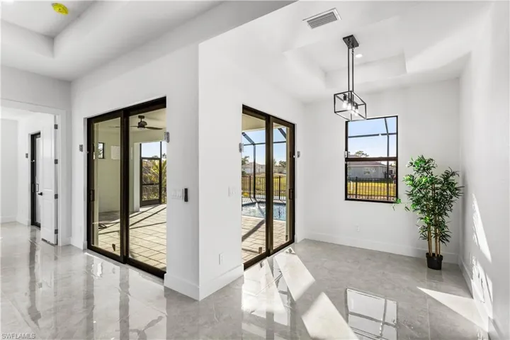 A formal dining area overlooks the freshwater canal and private pool, with sliding glass doors opening to the screened lanai, perfect for entertaining or relaxing!