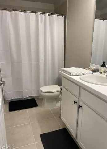 Full bath with vanity and tile patterned flooring