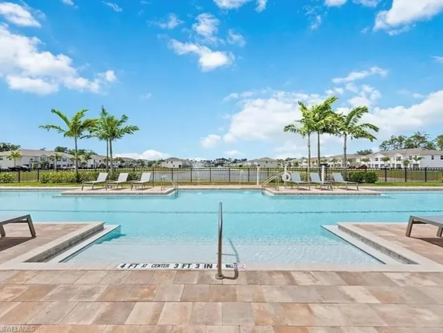 Community pool with a patio and a residential view