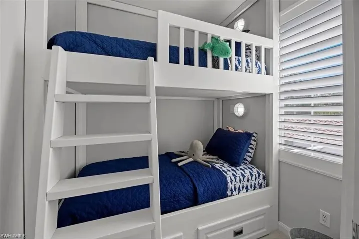 The property features built-in bunk beds with a ladder, individual wall-mounted lighting fixtures, and plantation shutters on the window